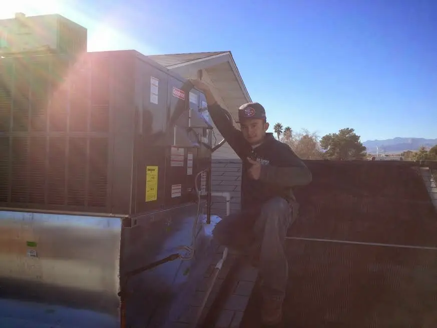 HVAC technician performing Air Duct Repair on a rooftop unit in Bellefonte